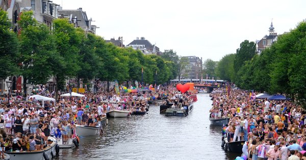 A crowd of people on boats on a canal in Amsterdam