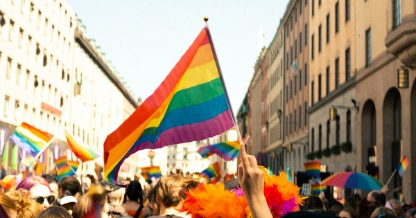 A crowd of marchers carrying rainbow flags at a Pride parade