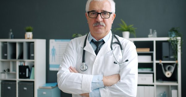 A doctor in a white coat standing in a clinic office