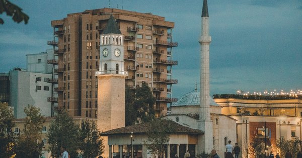 People crossing a central square in Tirana, Albania