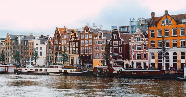 Boats decorated with rainbow flags on an Amsterdam canal during Pride