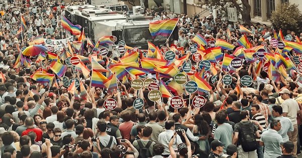 A crowd marching with rainbow flags through the streets of Zagreb, Croatia